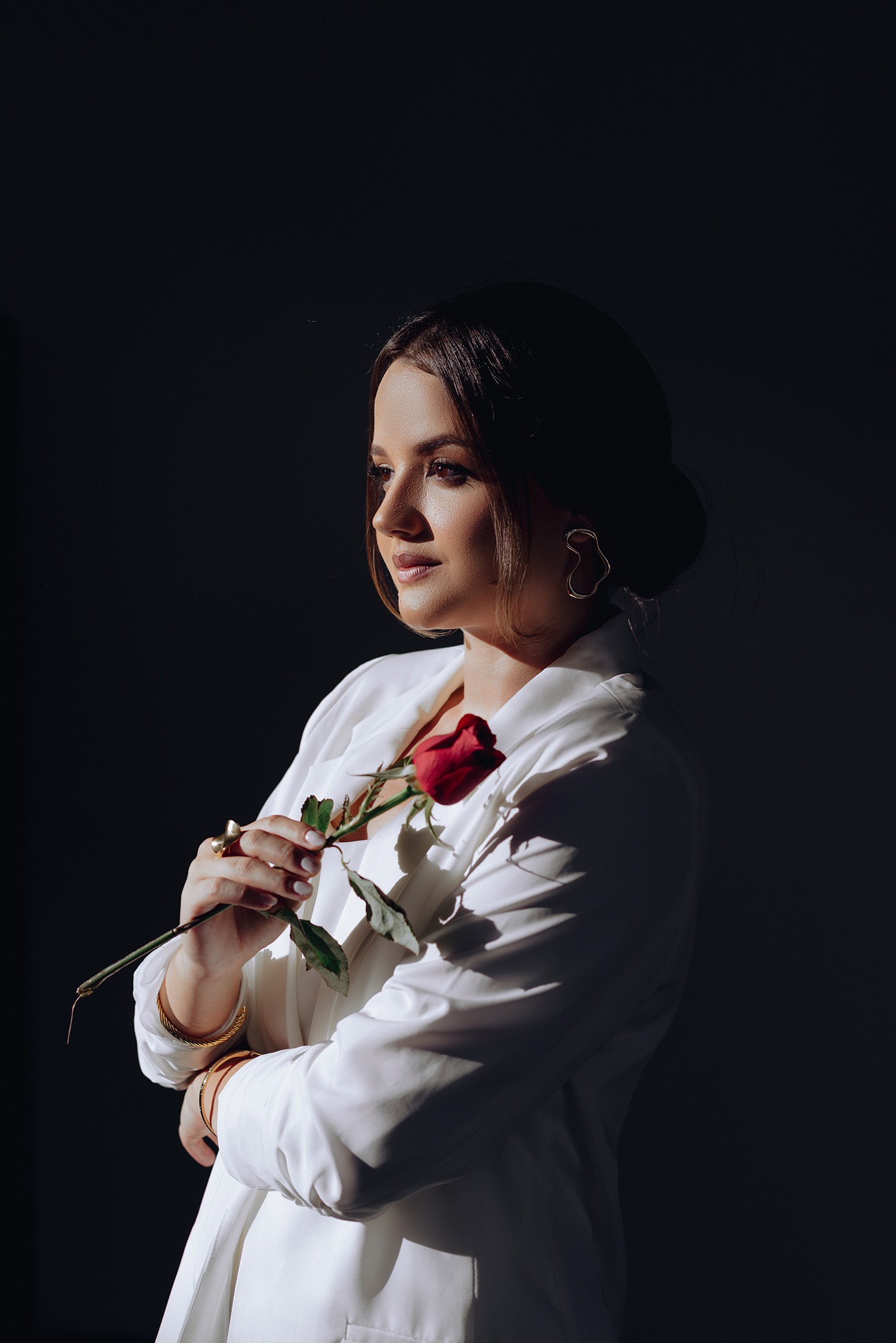 Noiva segurando uma rosa vermelha durante sua preparação